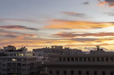 a city skyline with a cloudy sky at sunset at Central Athenian penthouse Acropolis in Athens