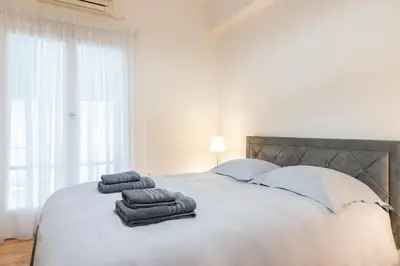 a white bed with two towels on top of it at Athens TAN Luxury Apartment In City Center 78m2 in Athens