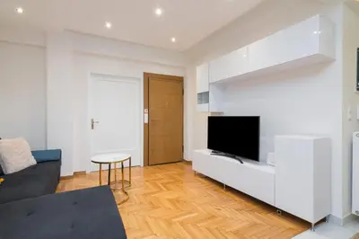 a living room with a tv and a couch at Athens TAN Luxury Apartment In City Center 78m2 in Athens
