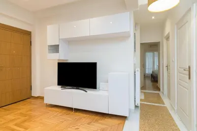 a white living room with a flat screen tv at Athens TAN Luxury Apartment In City Center 78m2 in Athens