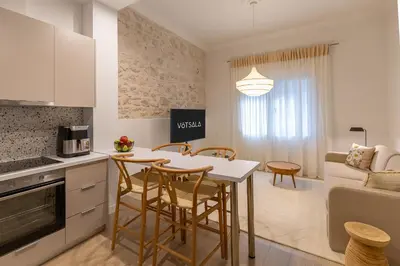 a kitchen and living room with a table and chairs at Votsala Deluxe & Modern Apartments in Piraeus in Piraeus