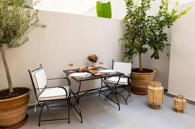 a table and chairs with plants on a patio at Votsala Deluxe & Modern Apartments in Piraeus in Piraeus