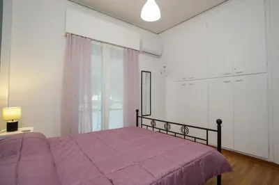 a bedroom with a purple bed and a window at Peppy's house in Athens