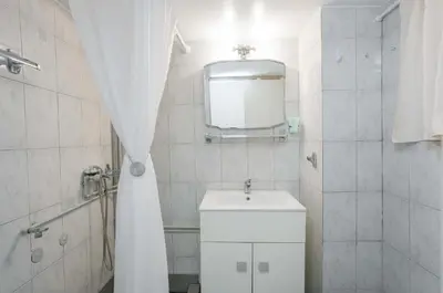 a white bathroom with a sink and a mirror at Peppy's house in Athens