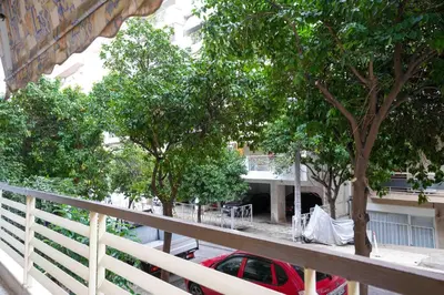 a balcony with a red car parked next to trees at Peppy's house in Athens