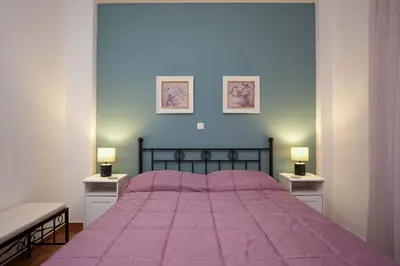 a bedroom with a bed with a purple blanket on it at Peppy's house in Athens