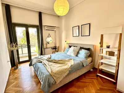 a bedroom with a bed with blue sheets and a window at Modern 2BD with City View Near Acropolis in Athens