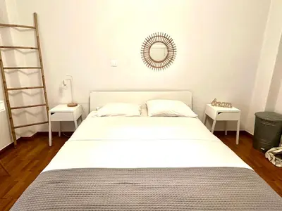 a bedroom with a bed and a mirror on the wall at Modern 2BD with City View Near Acropolis in Athens