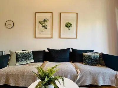 a living room with a couch and two pictures on the wall at Modern 2BD with City View Near Acropolis in Athens