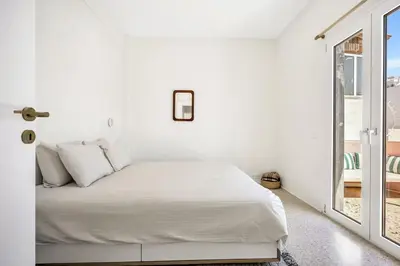 a white bedroom with a bed and a window at Designer comfy penthouse, Pagrati-