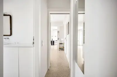 a hallway with white walls and a hallway with a mirror at Designer comfy penthouse, Pagrati-