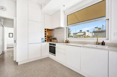 a kitchen with white cabinets and a large window at Designer comfy penthouse, Pagrati-