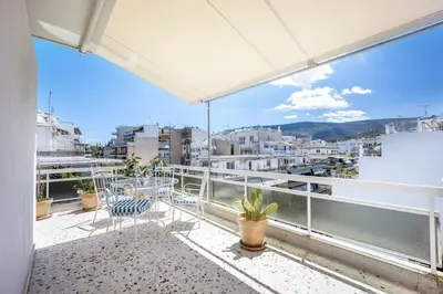 a balcony with chairs and a view of a city at Designer comfy penthouse, Pagrati-