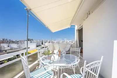 a balcony with a table and chairs and a view at Designer comfy penthouse, Pagrati-