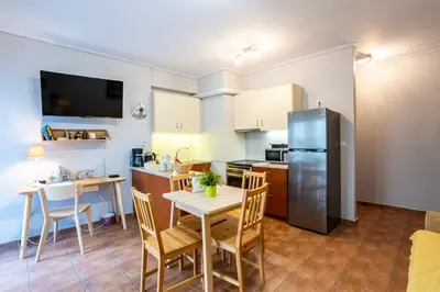a kitchen with a table and a refrigerator at Suite home in Athens