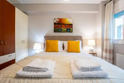 a bedroom with a large bed with two towels on it at Suite home in Athens