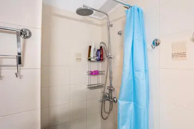 a shower with a blue shower curtain in a bathroom at Suite home in Athens