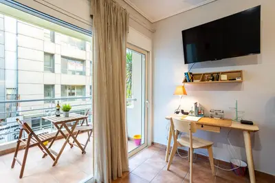 a room with a desk and a large window at Suite home in Athens