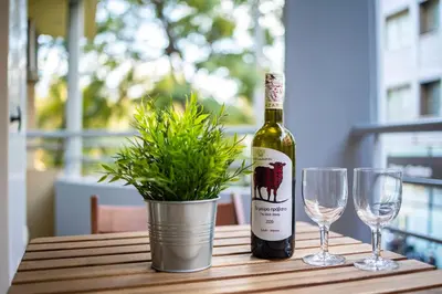 a bottle of wine and two wine glasses on a table at Suite home in Athens