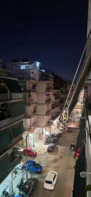 a street with cars parked in a parking lot at night at central elegant apartment in koukaki,near acropoli in Athens