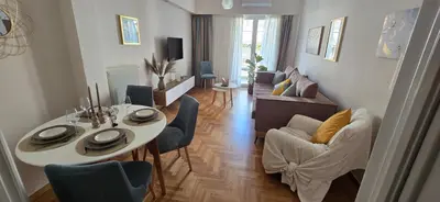 a living room with a table and chairs and a living room at central elegant apartment in koukaki,near acropoli in Athens