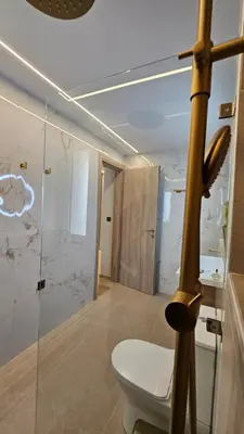 a bathroom with a toilet and a glass shower stall at Mark1 by Apollo in Markopoulo