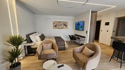 a bedroom with a bed and two chairs and a piano at Mark1 by Apollo in Markopoulo