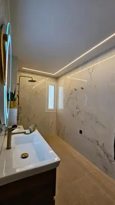 a bathroom with a sink and a marble wall at Mark1 by Apollo in Markopoulo