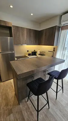 a kitchen with a large counter with two chairs at Mark1 by Apollo in Markopoulo