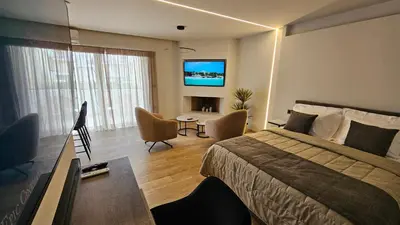 a hotel room with a bed and a flat screen tv at Mark1 by Apollo in Markopoulo