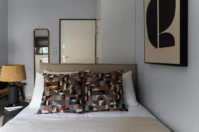 a bedroom with a bed with a mirror on the wall at Piraeus Gem - Netflix, Nespresso and Style in Piraeus