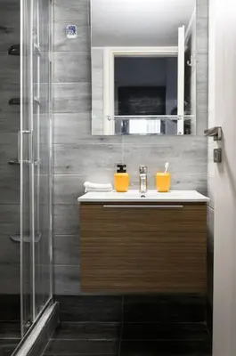 a bathroom with a sink and a shower at Piraeus Gem - Netflix, Nespresso and Style in Piraeus