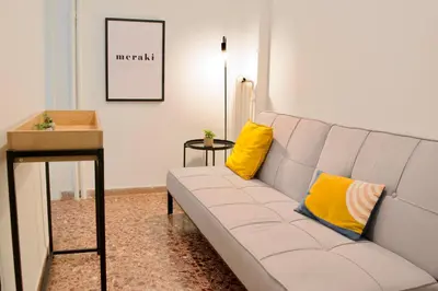 a white couch with two yellow pillows in a living room at A Very Friendly and Central Home in Athens