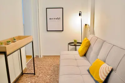 a living room with a white couch and yellow pillows at A Very Friendly and Central Home in Athens