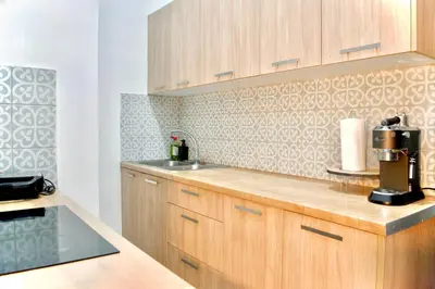 a kitchen with wooden cabinets and a coffee maker on a counter at A Very Friendly and Central Home in Athens