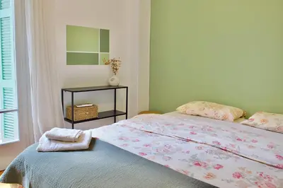 a bedroom with a bed and a table with a mirror at A Very Friendly and Central Home in Athens