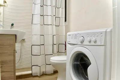 a washing machine in a bathroom with a toilet at A Very Friendly and Central Home in Athens