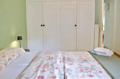a bedroom with a large bed with white cabinets at A Very Friendly and Central Home in Athens