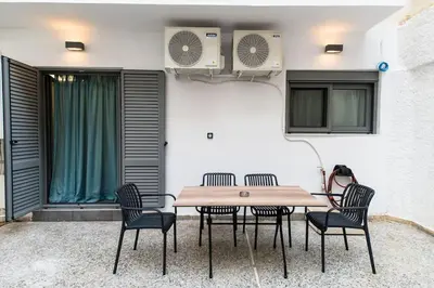 a table and chairs with a table and a fan at Fix Central Athens Nomads in Athens