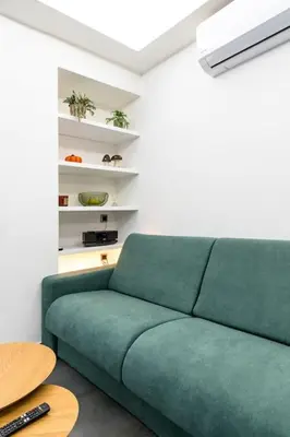 a green couch in a living room with a table at Fix Central Athens Nomads in Athens