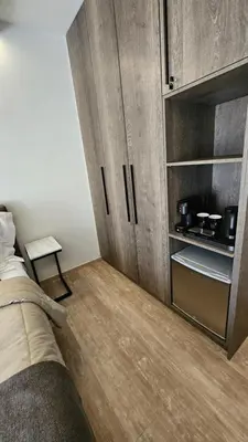 a bedroom with a bed and wooden cabinets at Mark2 by Apollo in Markopoulo