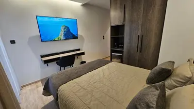 a bedroom with a bed and a television on a wall at Mark2 by Apollo in Markopoulo