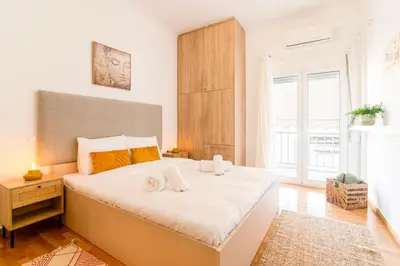 a bedroom with a large white bed and a window at Nataly's Vibrant 2BR - 4 mins walk to Acropolis in Athens