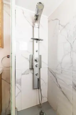 a shower with a shower head in a bathroom at Nataly's Vibrant 2BR - 4 mins walk to Acropolis in Athens