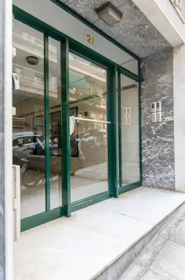 a glass door of a building with a car inside at Nataly's Vibrant 2BR - 4 mins walk to Acropolis in Athens