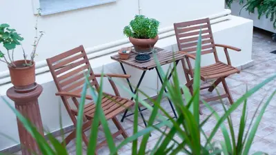 two chairs and a table with plants on a porch at ErexthionDiony2Apartments in Athens