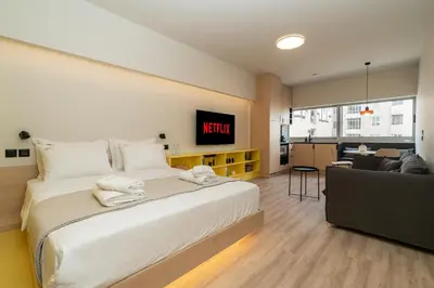 a bedroom with a large bed with a tv on the wall at Elegant Suite - Aiolou Street in Athens