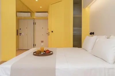 a bed with a plate of fruit and a bottle of juice at Elegant Suite - Aiolou Street in Athens