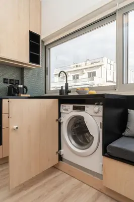 a washing machine in a kitchen with a window at Elegant Suite - Aiolou Street in Athens