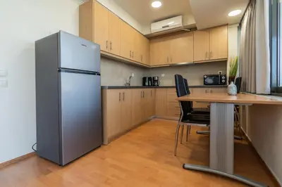 a kitchen with a stainless steel refrigerator and a table at Kifisias View Apartment 2 in Athens